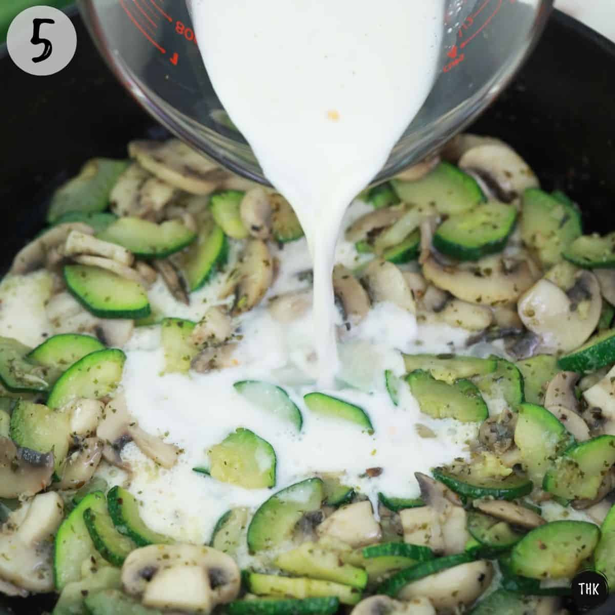 Milk mixture being poured on top of sautéed vegetables.