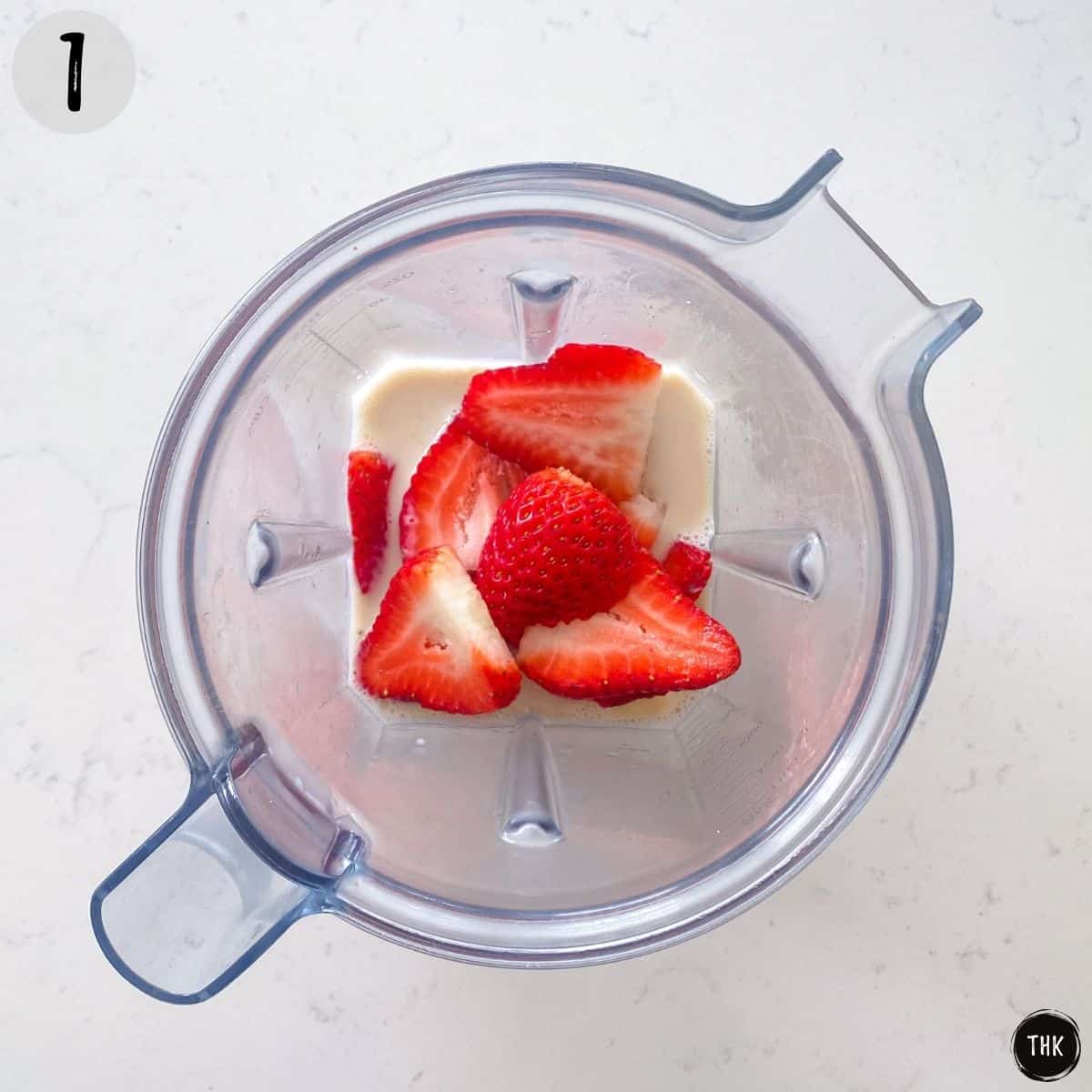 Strawberries, banana and milk in blender.