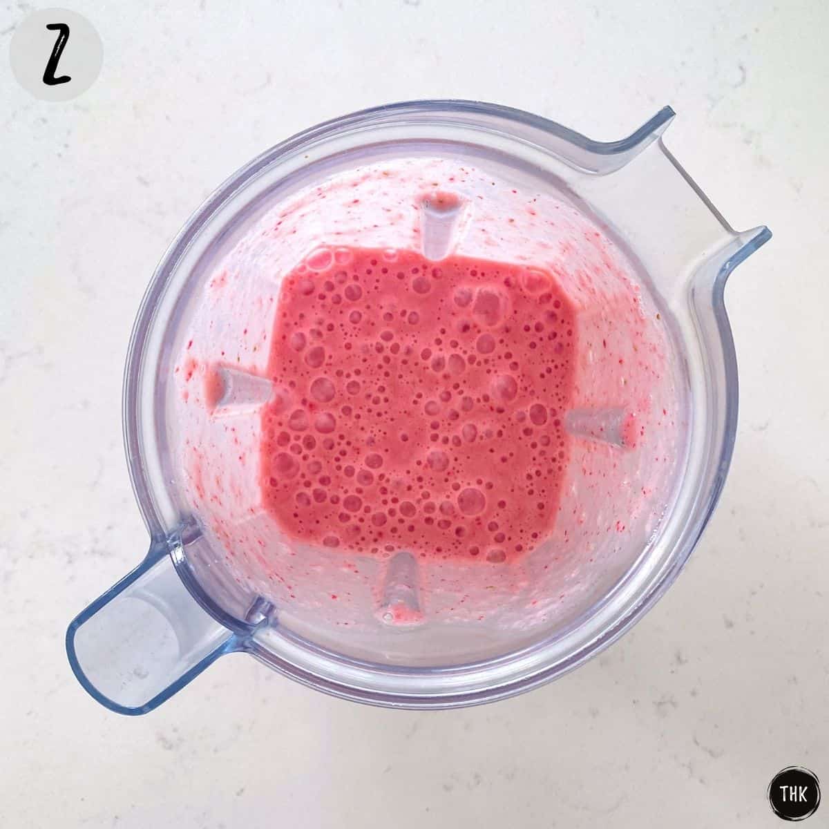 Pink pureed liquid inside blender.