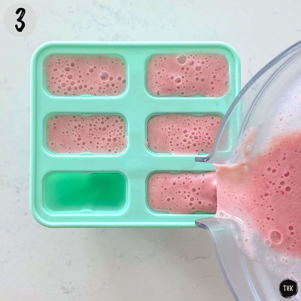 Pour pink liquid from blender into popsicle mold.