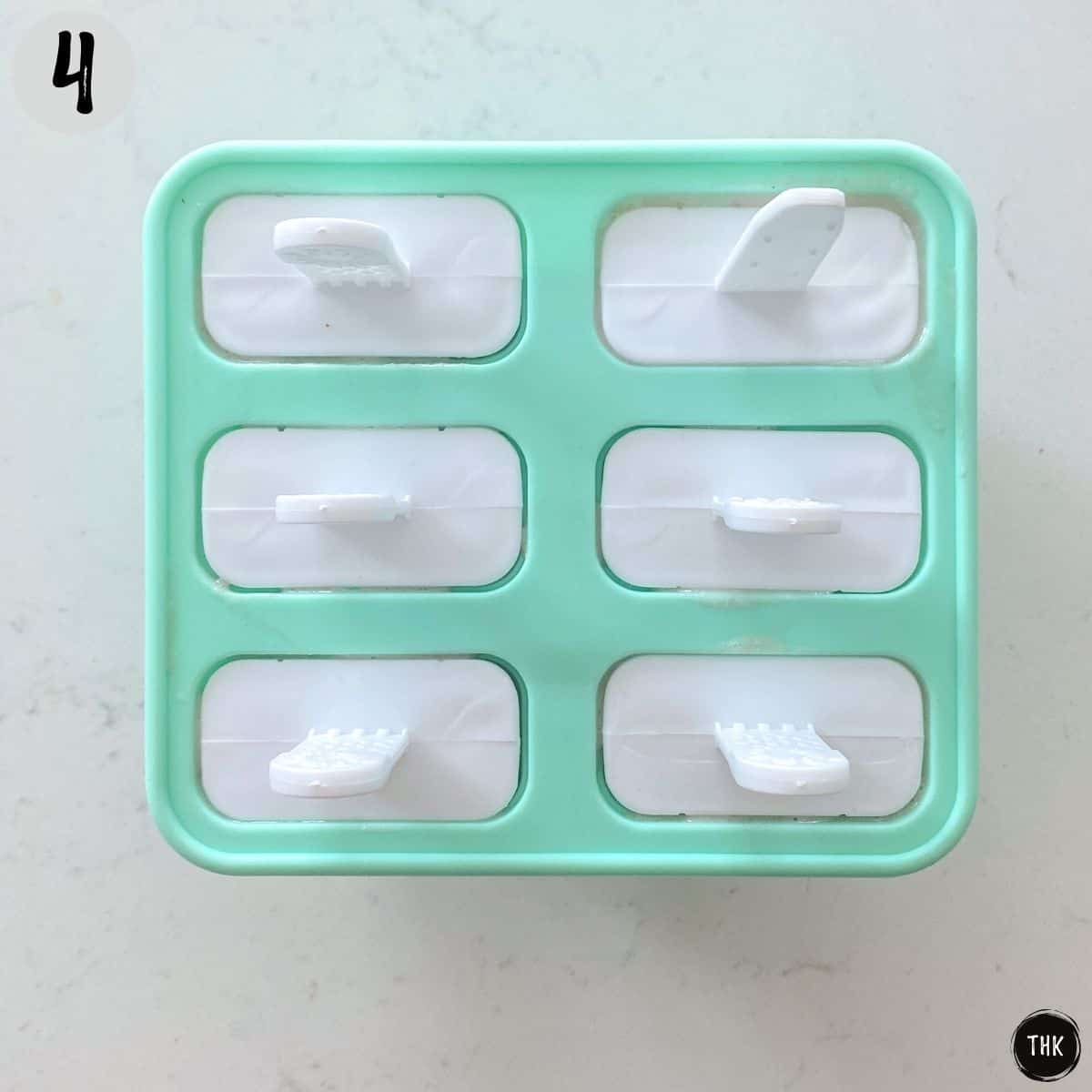 Silicone popsicle mold with all six lids on top.