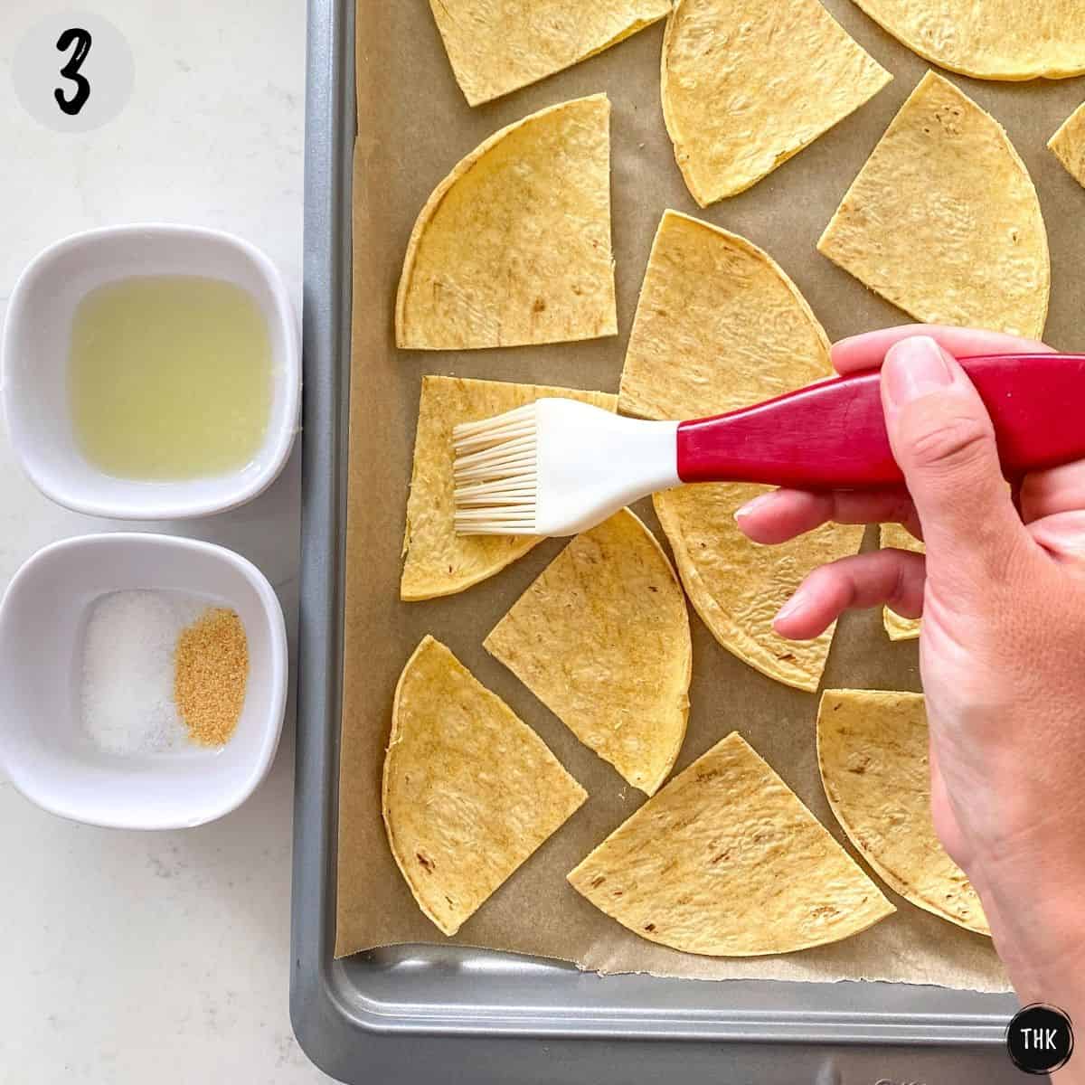 Silicone brush brushing liquid onto quartered tortilla pieces.