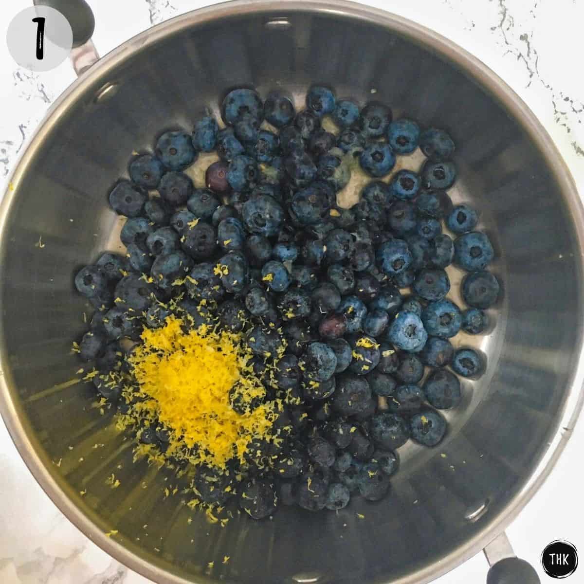 Blueberries and lemon zest inside medium pot.
