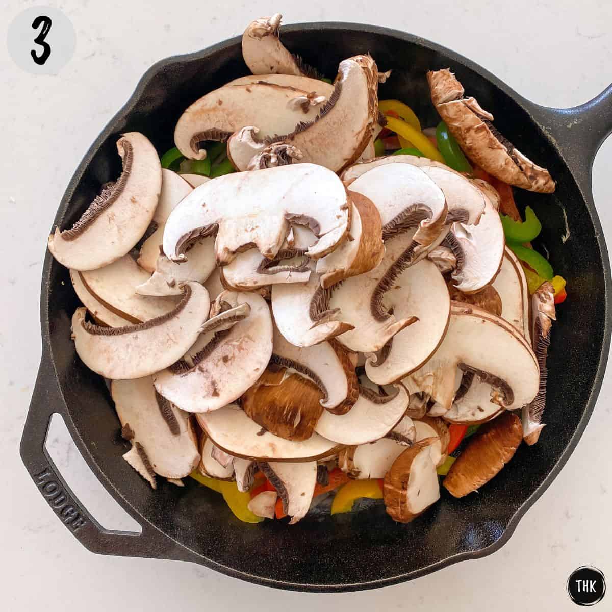 Sliced portobello mushrooms in cast iron pan.