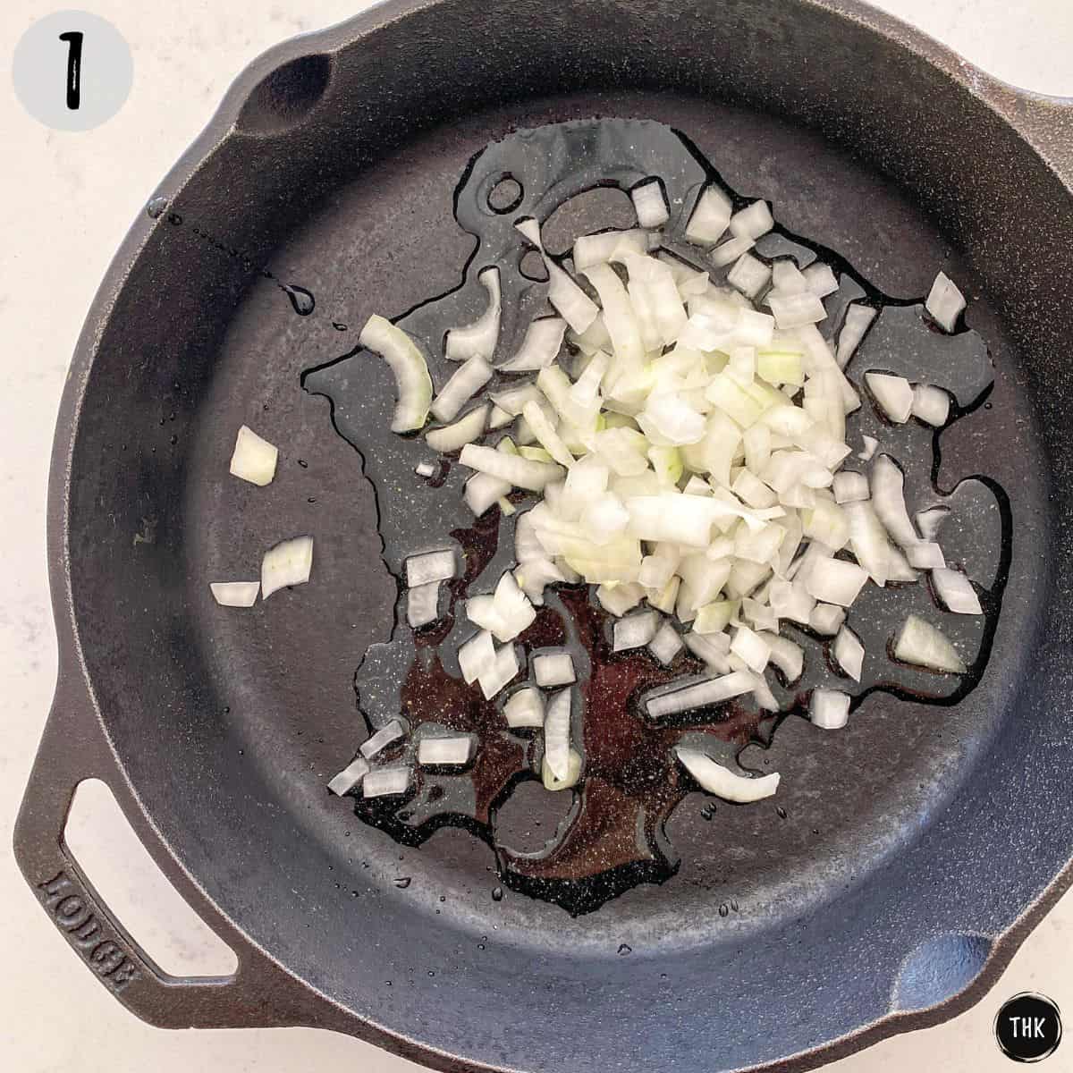 Water and diced onion in cast iron pan.