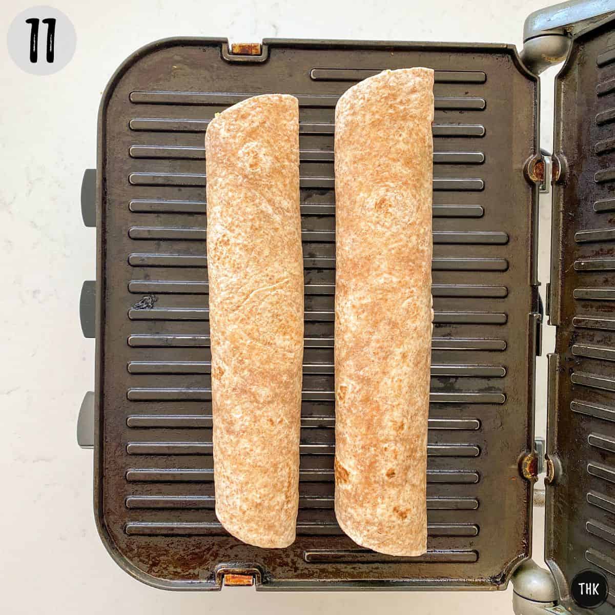Two tortilla rolls on panini press.
