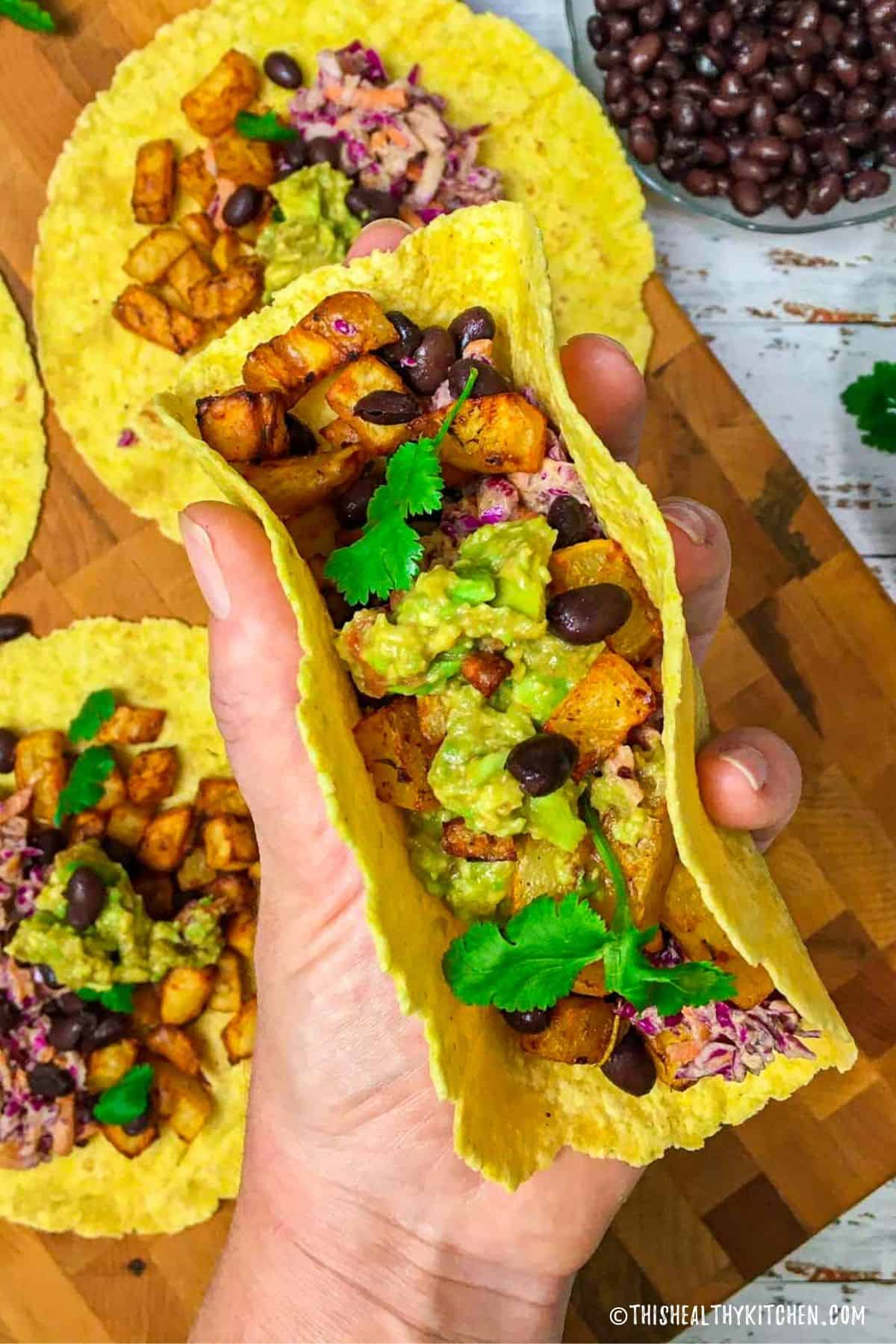 Corn tortillas stuffed with potatoes, black beans, guacamole and coleslaw.