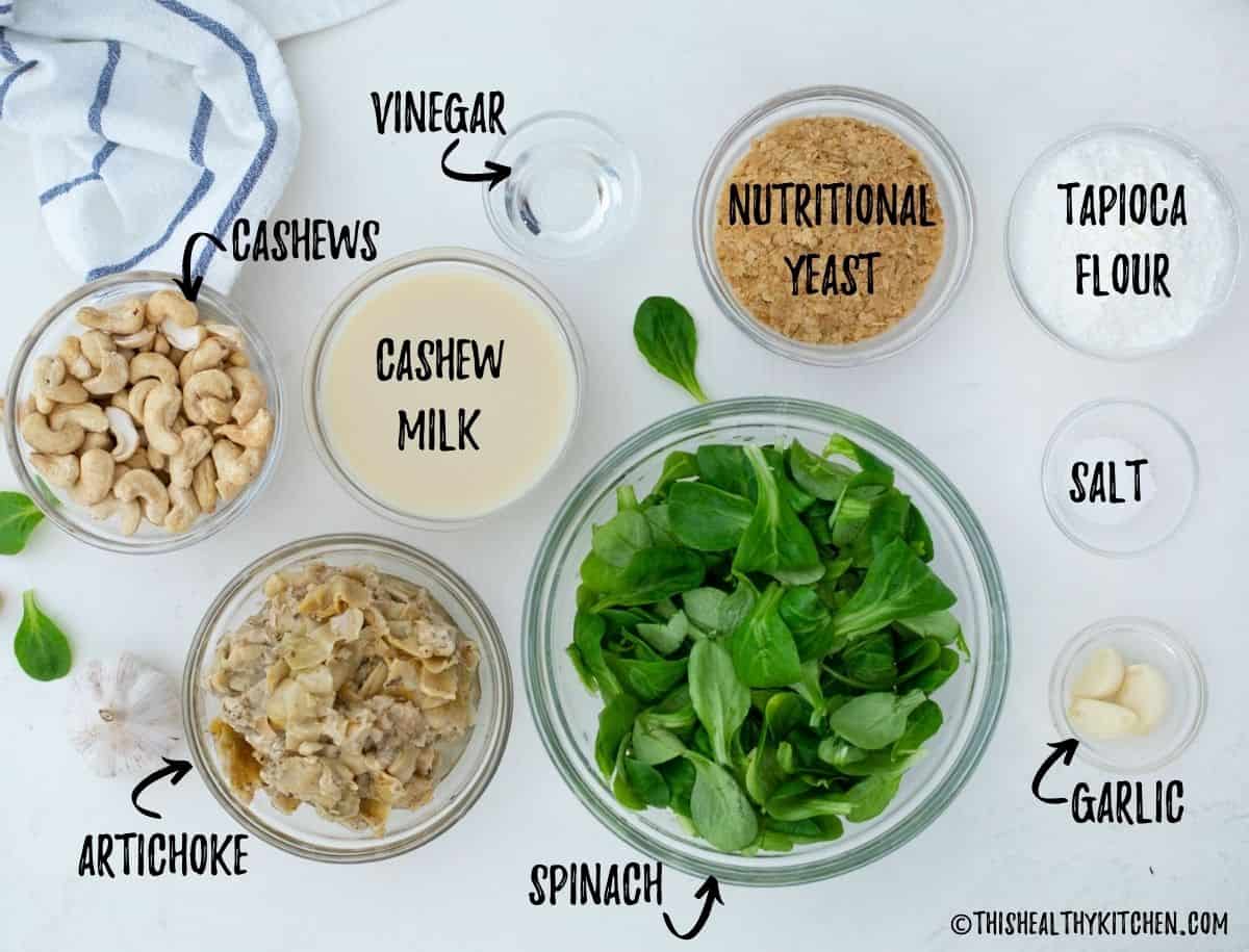 Ingredients needed to make vegan spinach artichoke dip in small prep bowls.