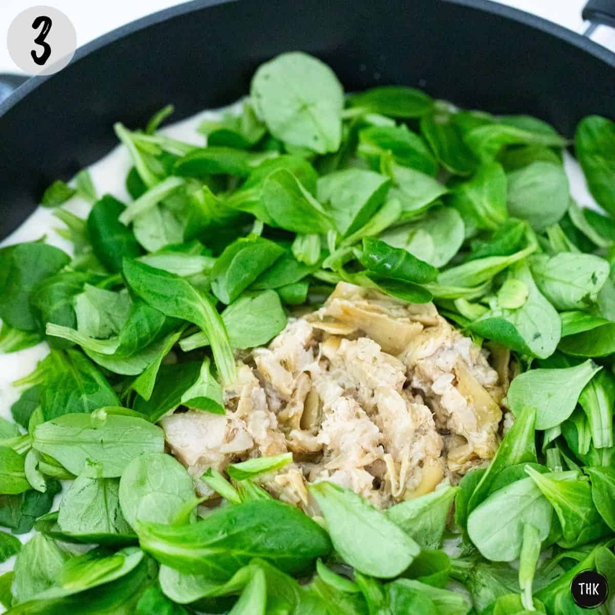 Spinach and artichokes in a large skillet.