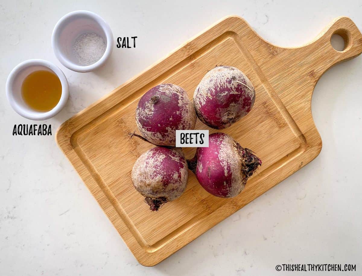 Raw beets on cutting board with salt and aquafaba on the side.