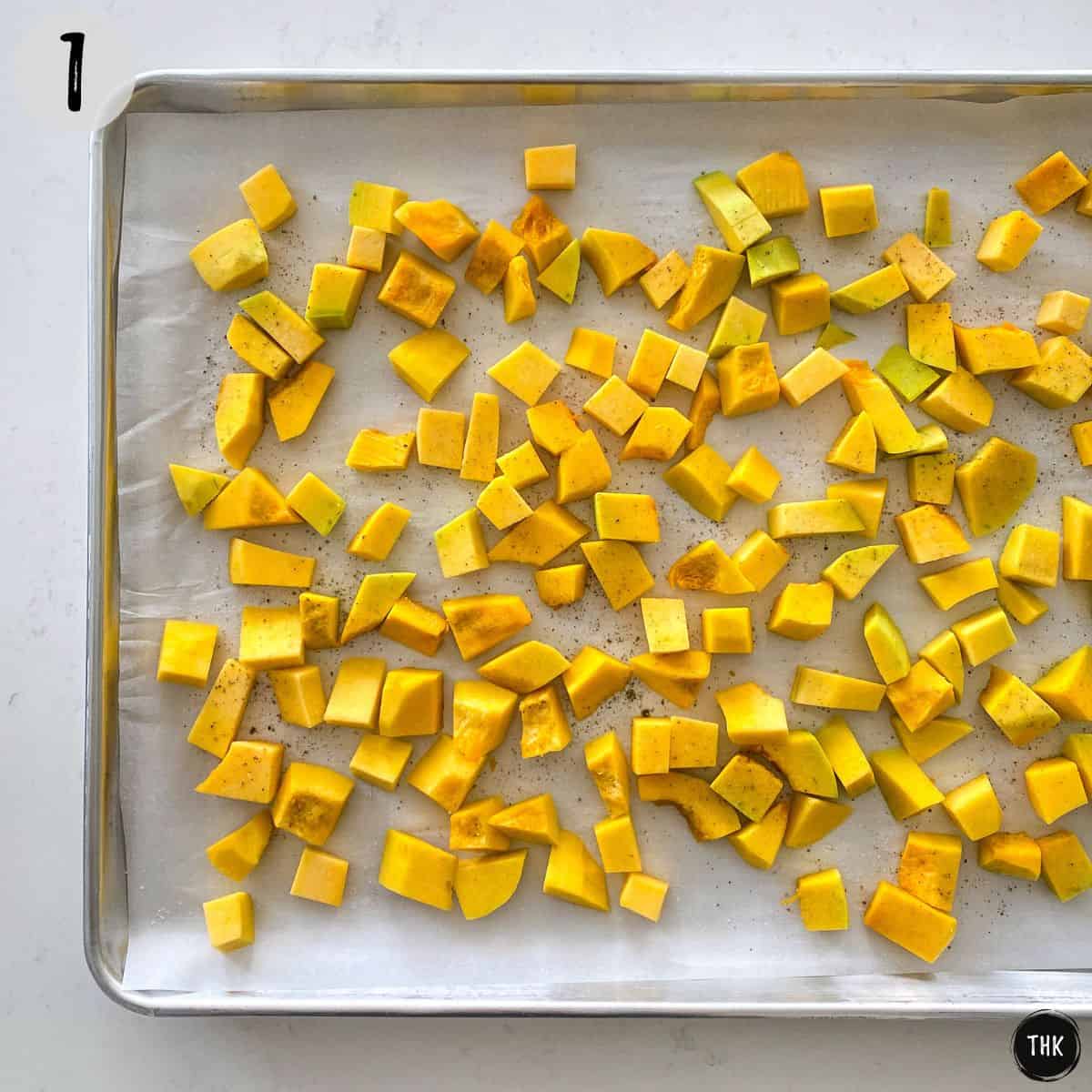 Cubed butternut squash in baking tray.