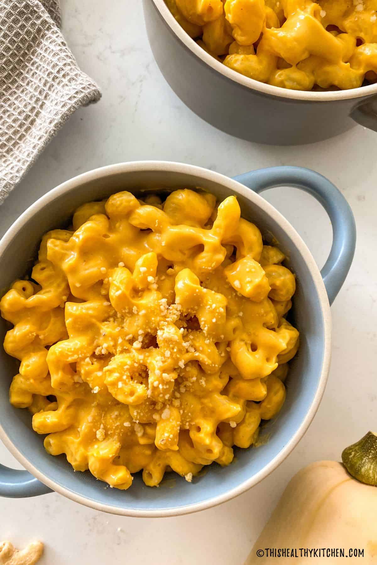 Mac and cheese in blue bowl with handles.