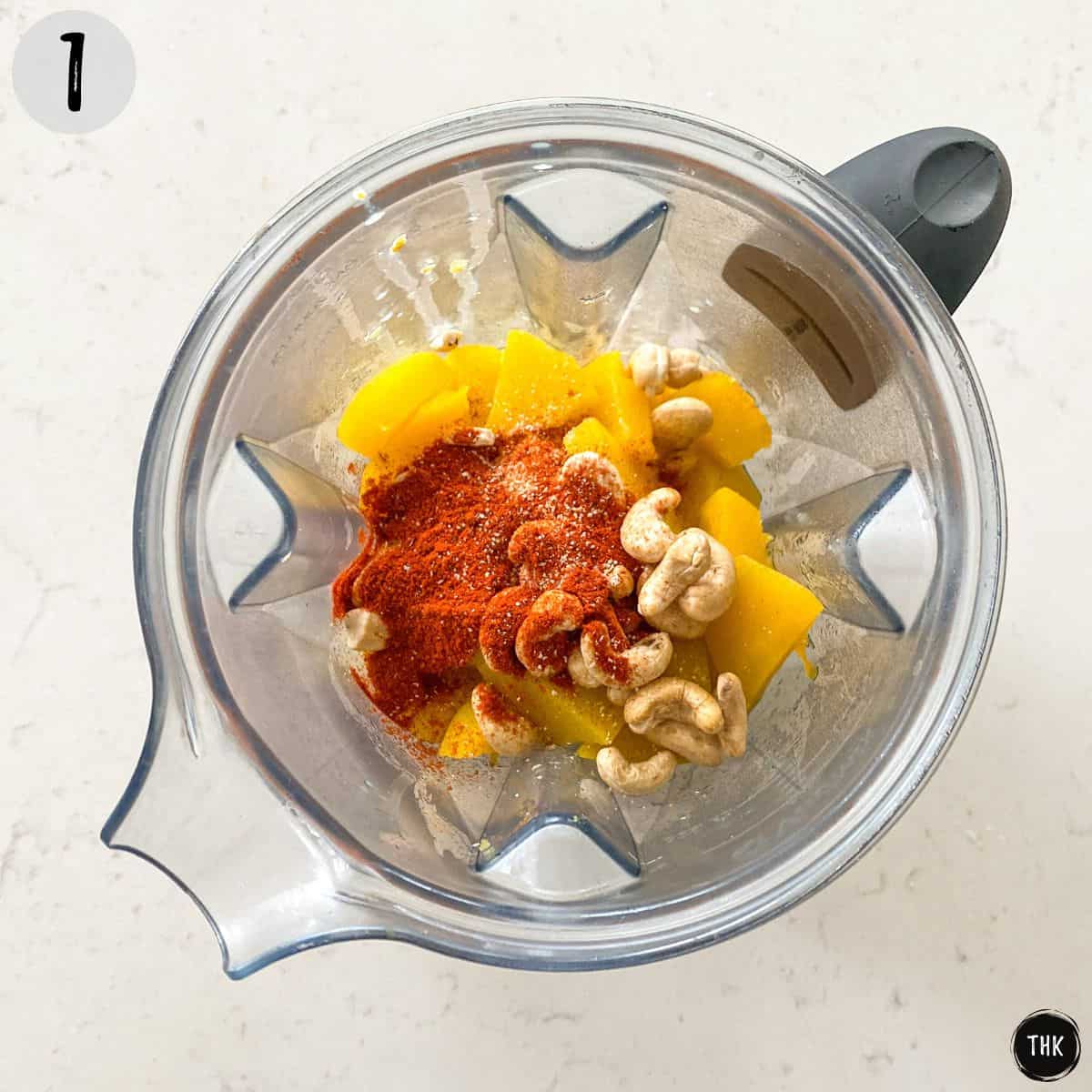 Blender with squash, cashews, and spices inside.