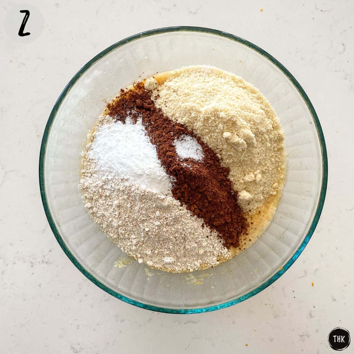 Large bowl with flour, cocoa powder and baking powder inside.
