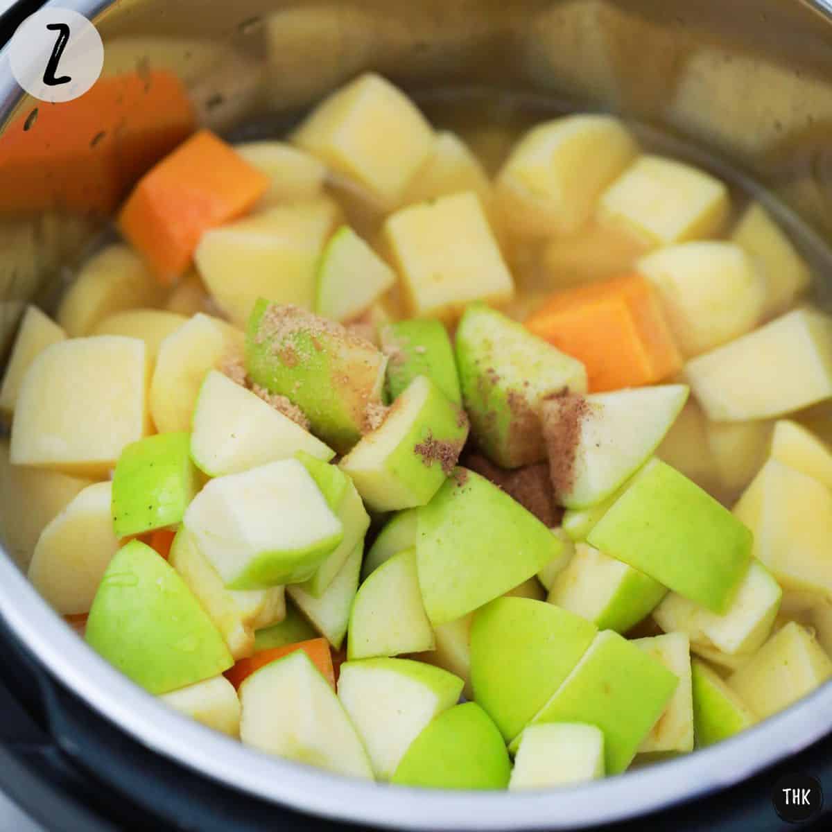 Pot of soup with chunks of apple, squash, potato, broth and spices.