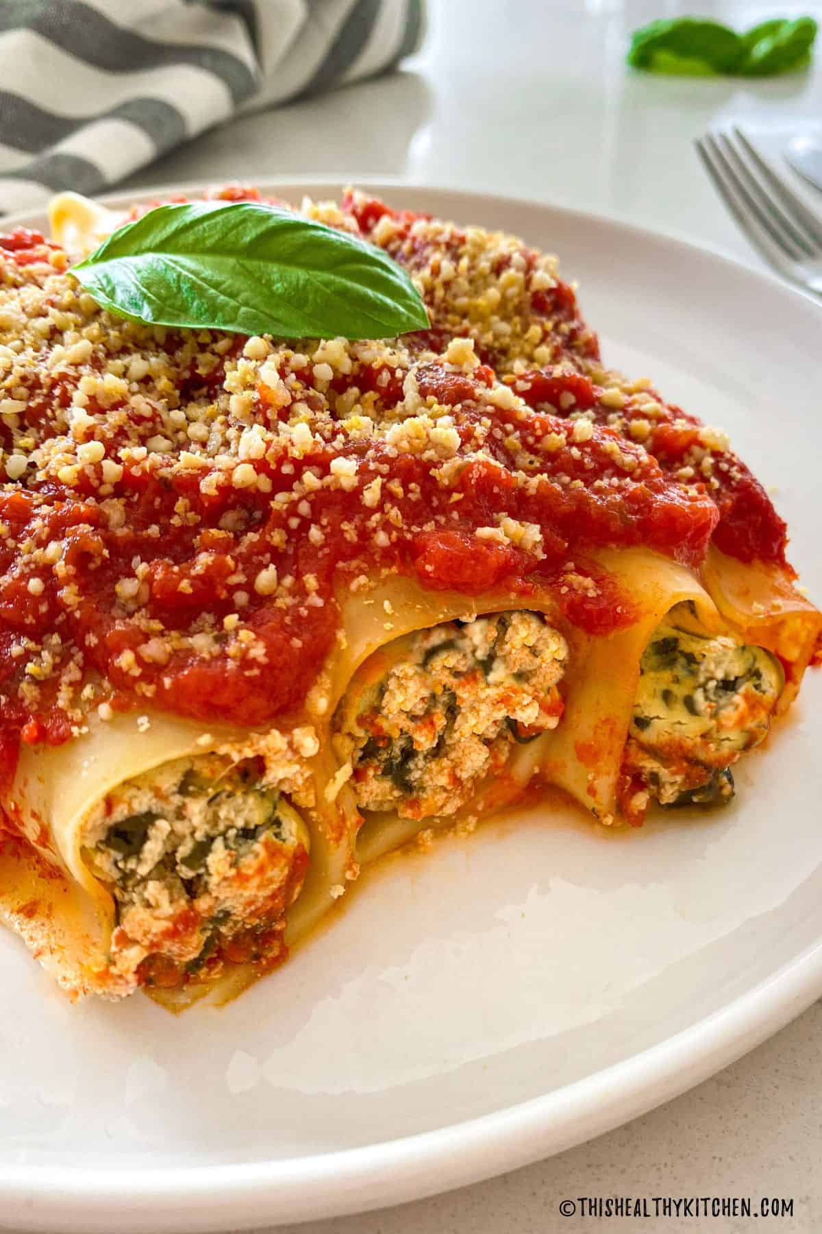 Side view of stuffed vegan cannelloni with ricotta and spinach filling.
