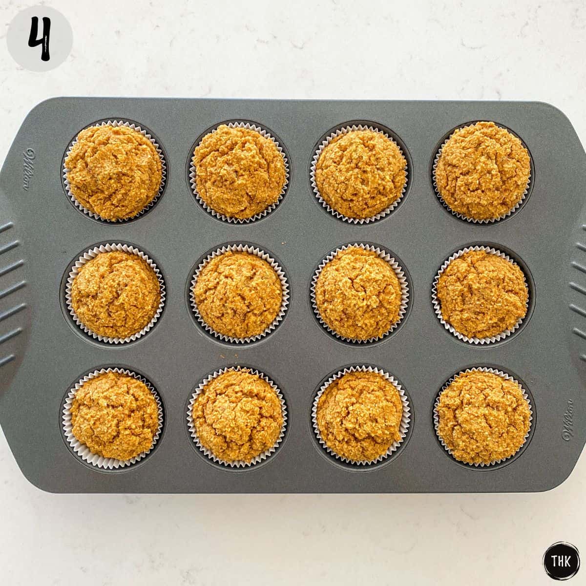 Baked pumpkin cupcakes in muffin pan with no frosting.
