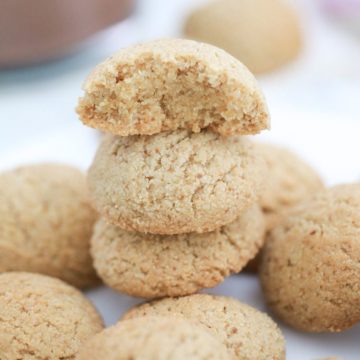 Almond flour cookies in a stack with top one cut in half.