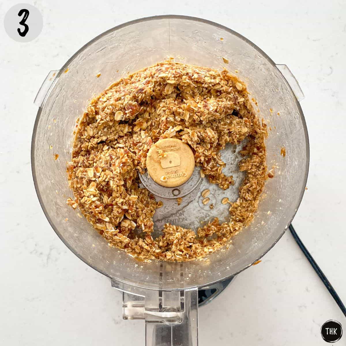 Date and oat mixture in bowl of food processor.
