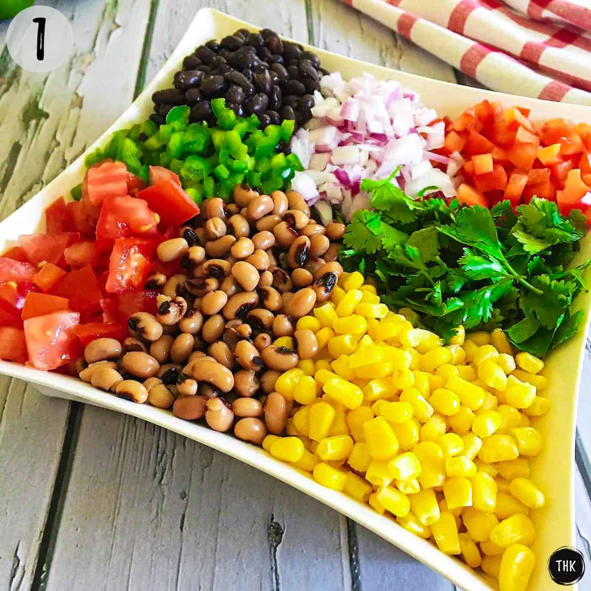 Beans, veggies, cilantro and corn in white bowl.