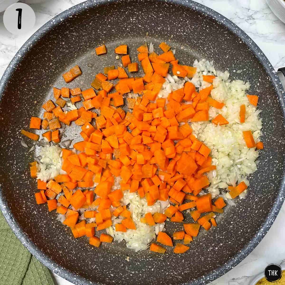 Diced onion and carrots in frying pan.