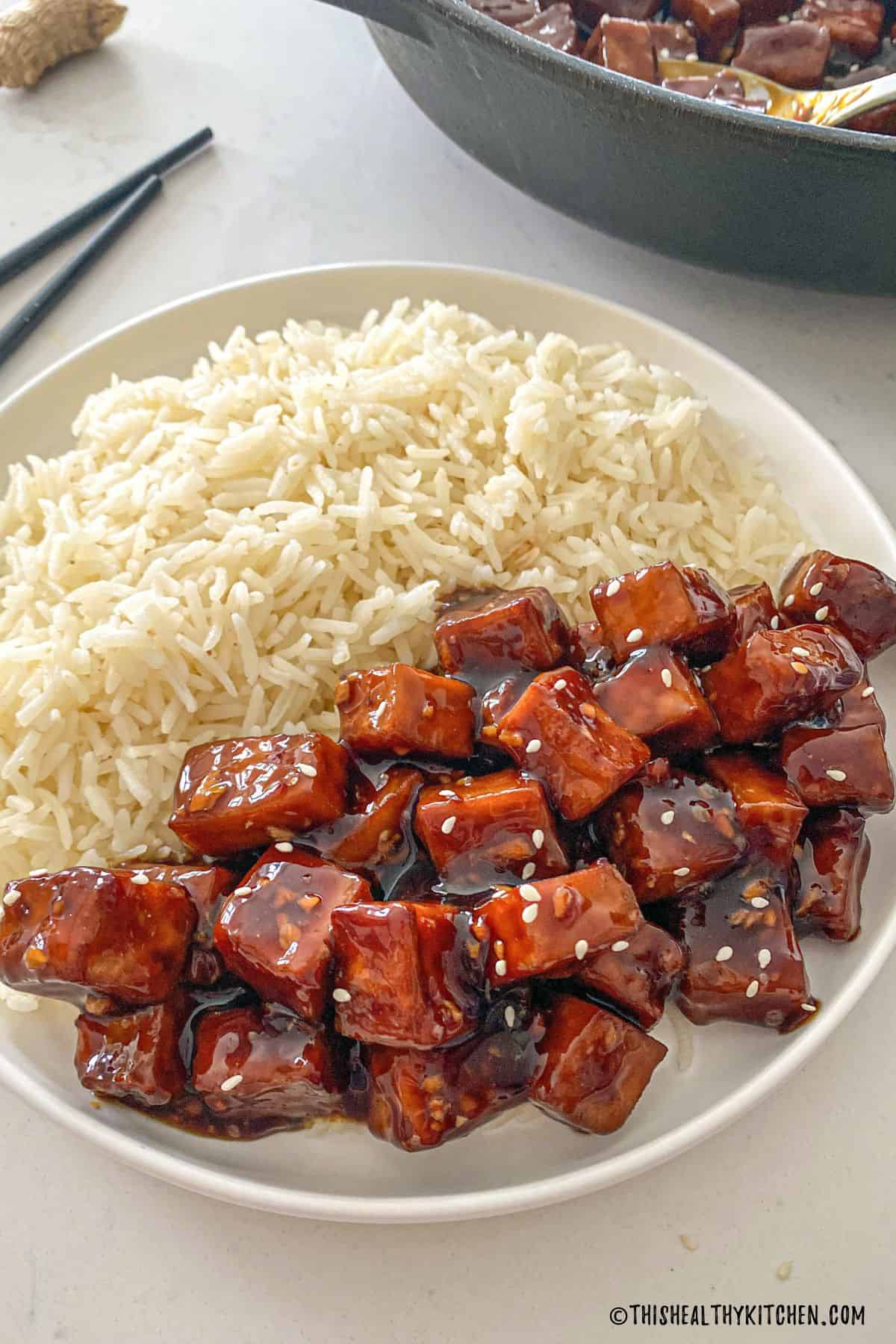 Plate with rice on one half and mongolian tofu on the other half.