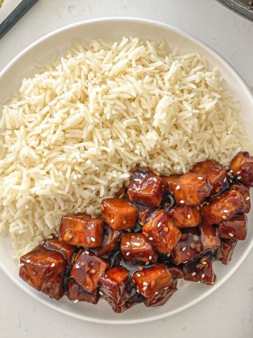 Plate with rice on one half and mongolian tofu on the other half.
