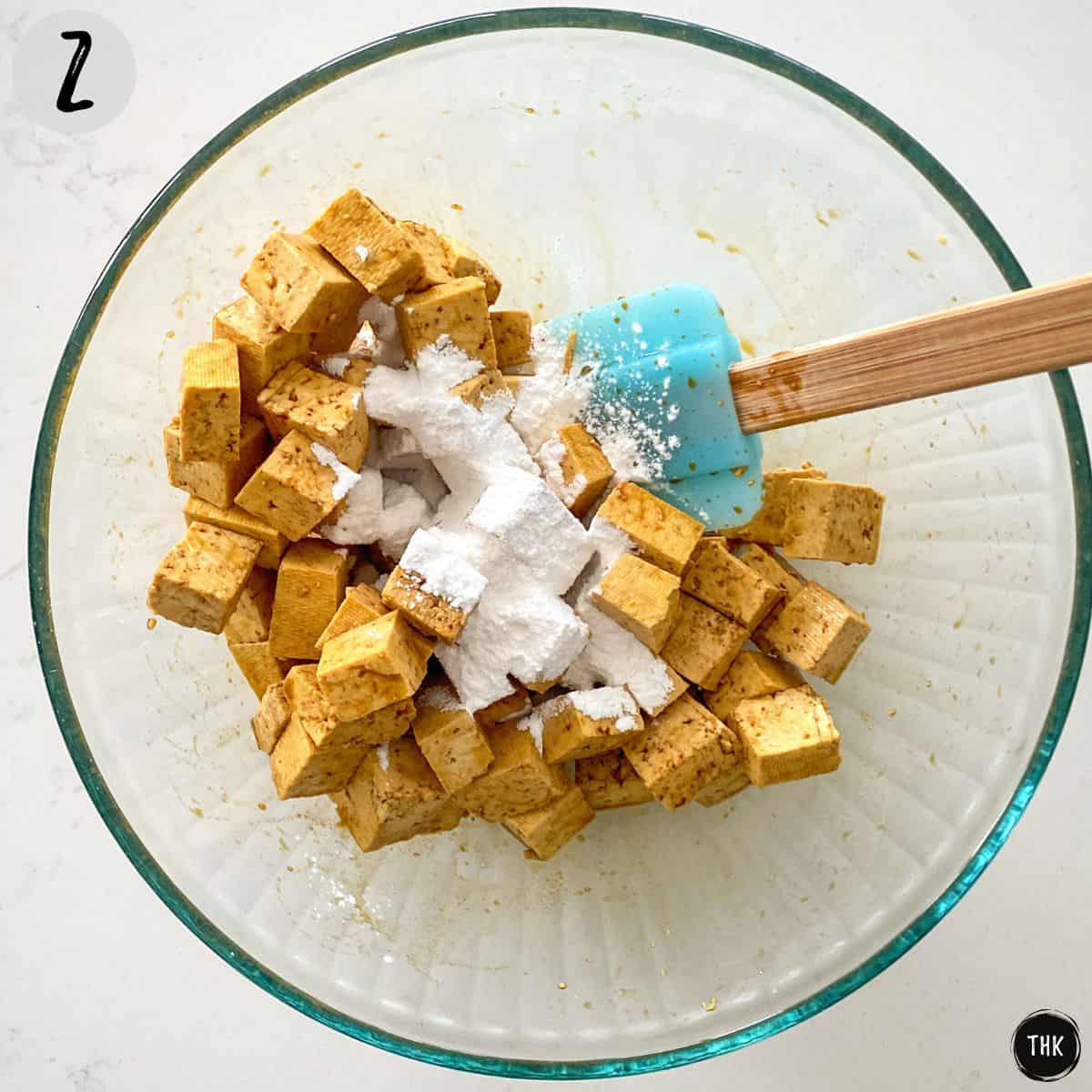 Mixing bowl with tofu and flour on top.