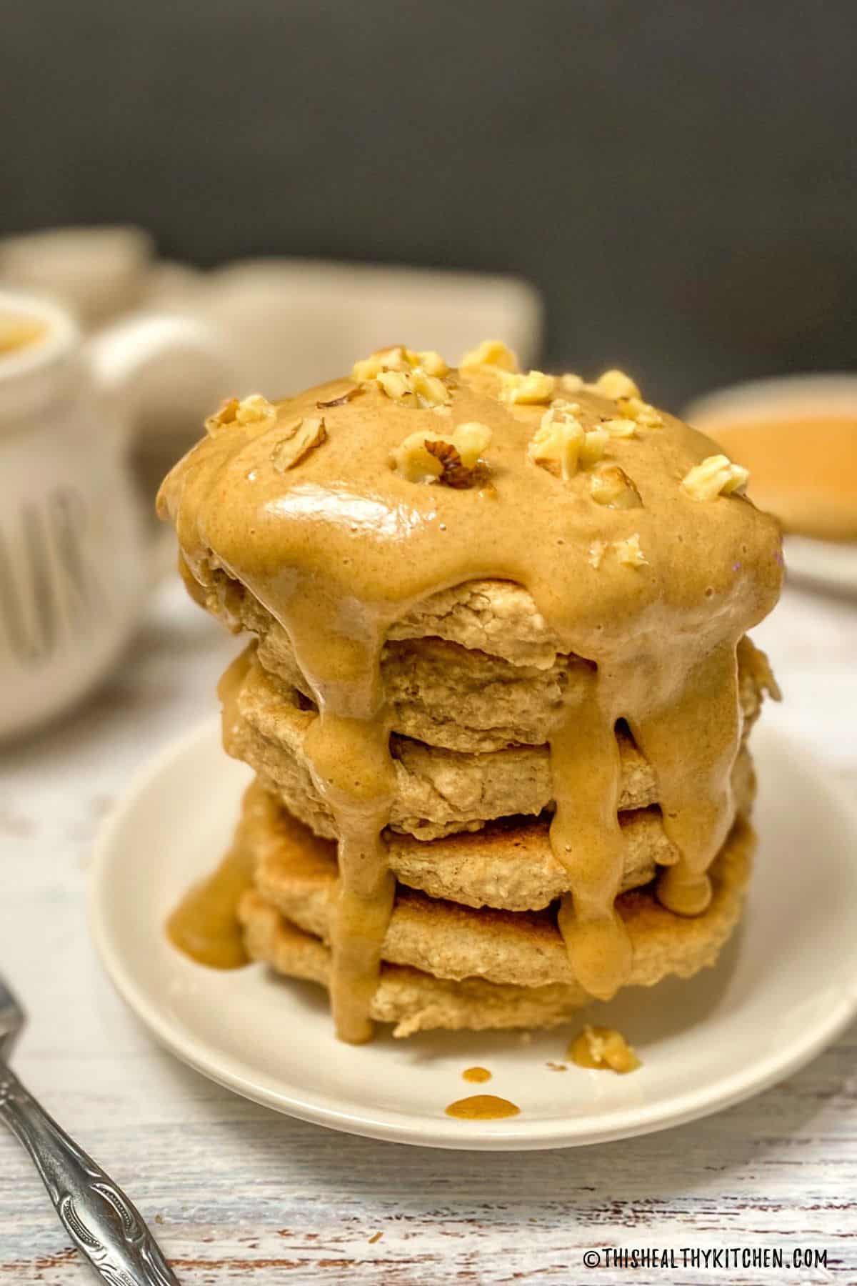 Stack of vegan peanut butter pancakes with peanut butter caramel on top.