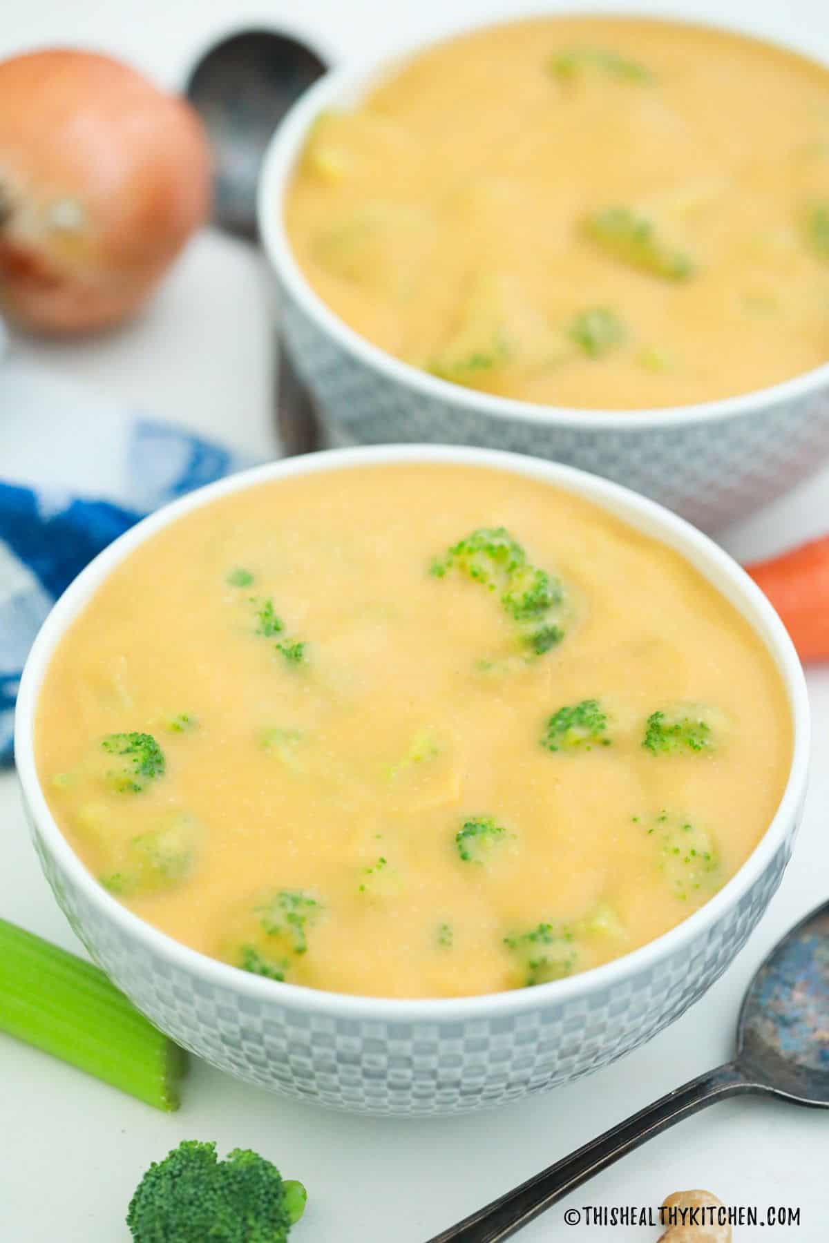 Two bowls of vegan cheesy broccoli soup.