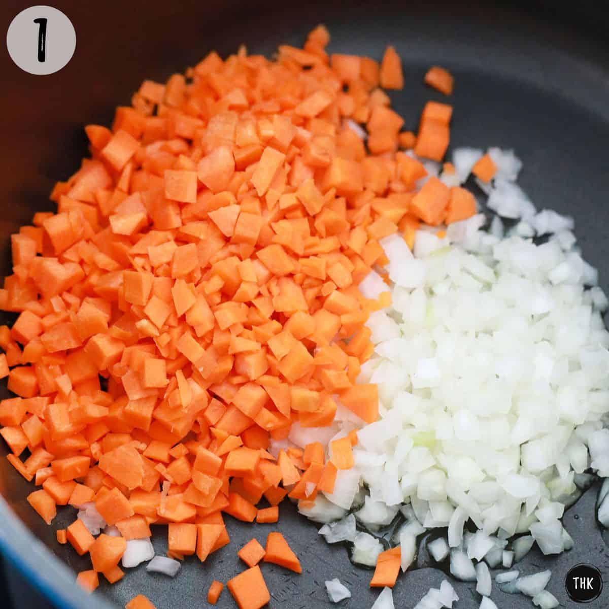 Diced carrots and onion inside large pot.