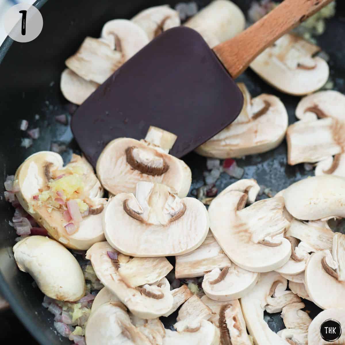 Onion, garlic and mushrooms being sauteed in pan.