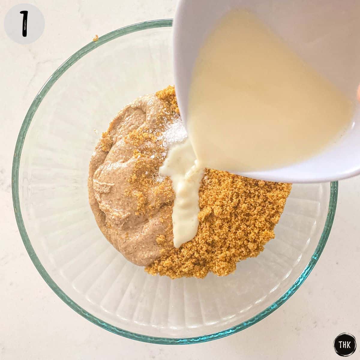 Milk pouring into bowl with dry ingredients.
