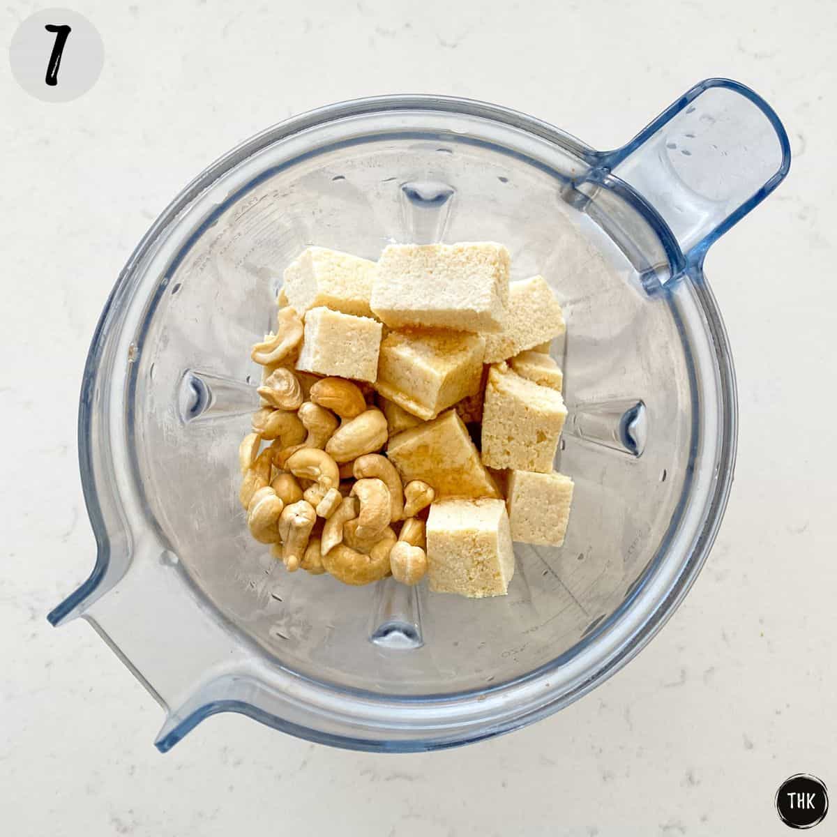 Blender with tofu cubes, cashews, and maple syrup.