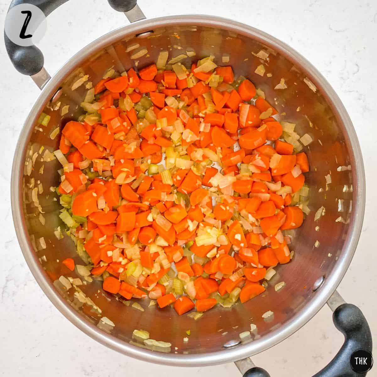 Pot with sauteed onion, carrot, celery and garlic.