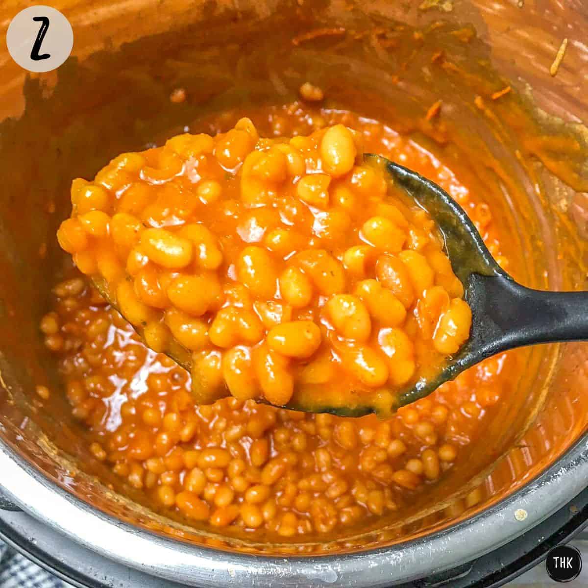 Scoop of cooked baked beans inside Instant Pot.