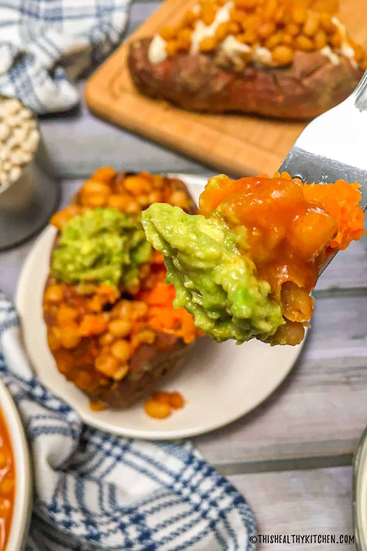 Forkful of sweet potato with beans and guacamole.