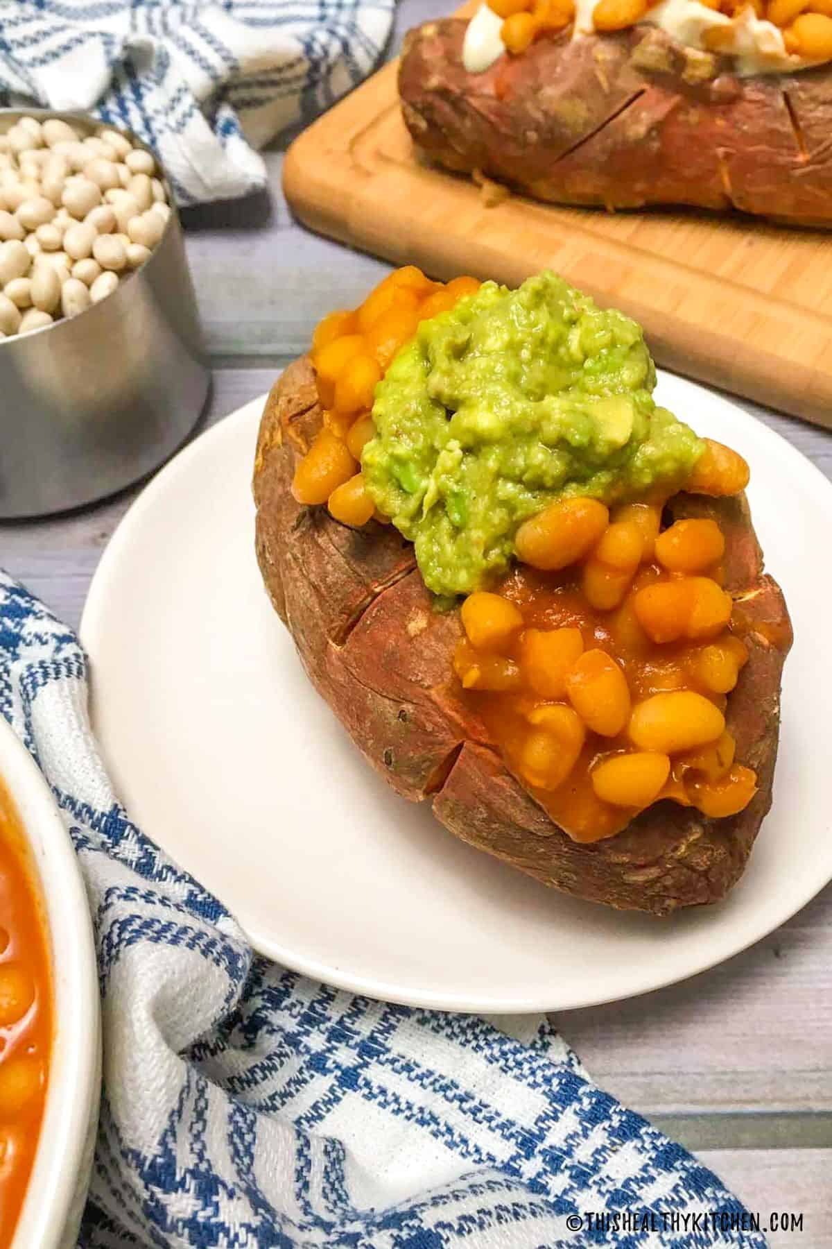 Loaded sweet potato with baked beans and guacamole.
