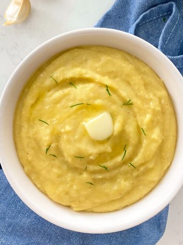 Mashed polenta with butter and chives on top.