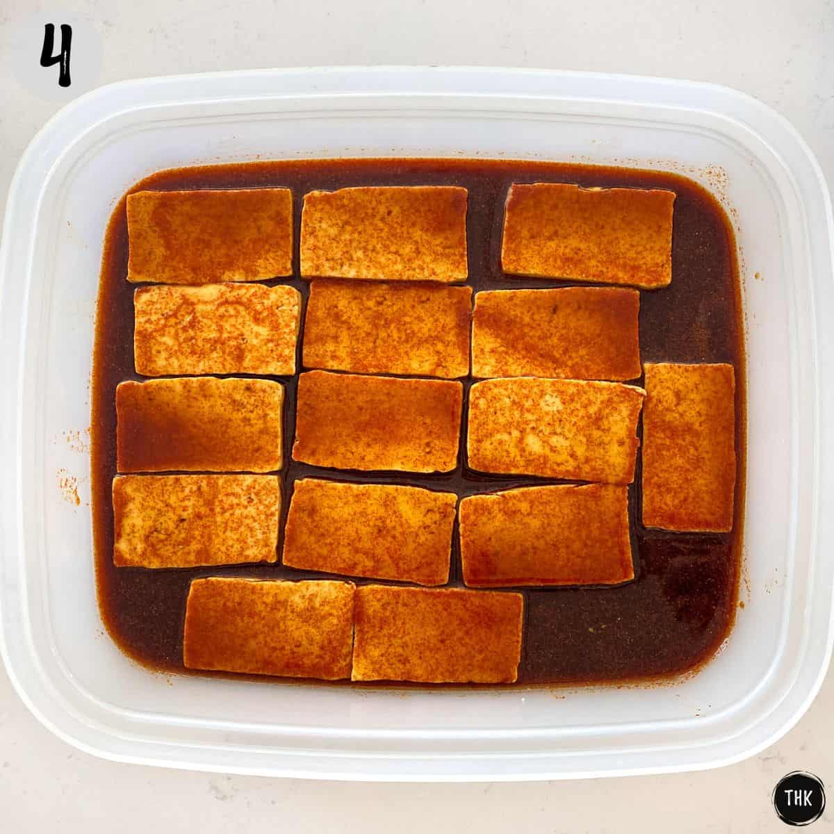 Tofu in wide, shallow dish covered in marinade.