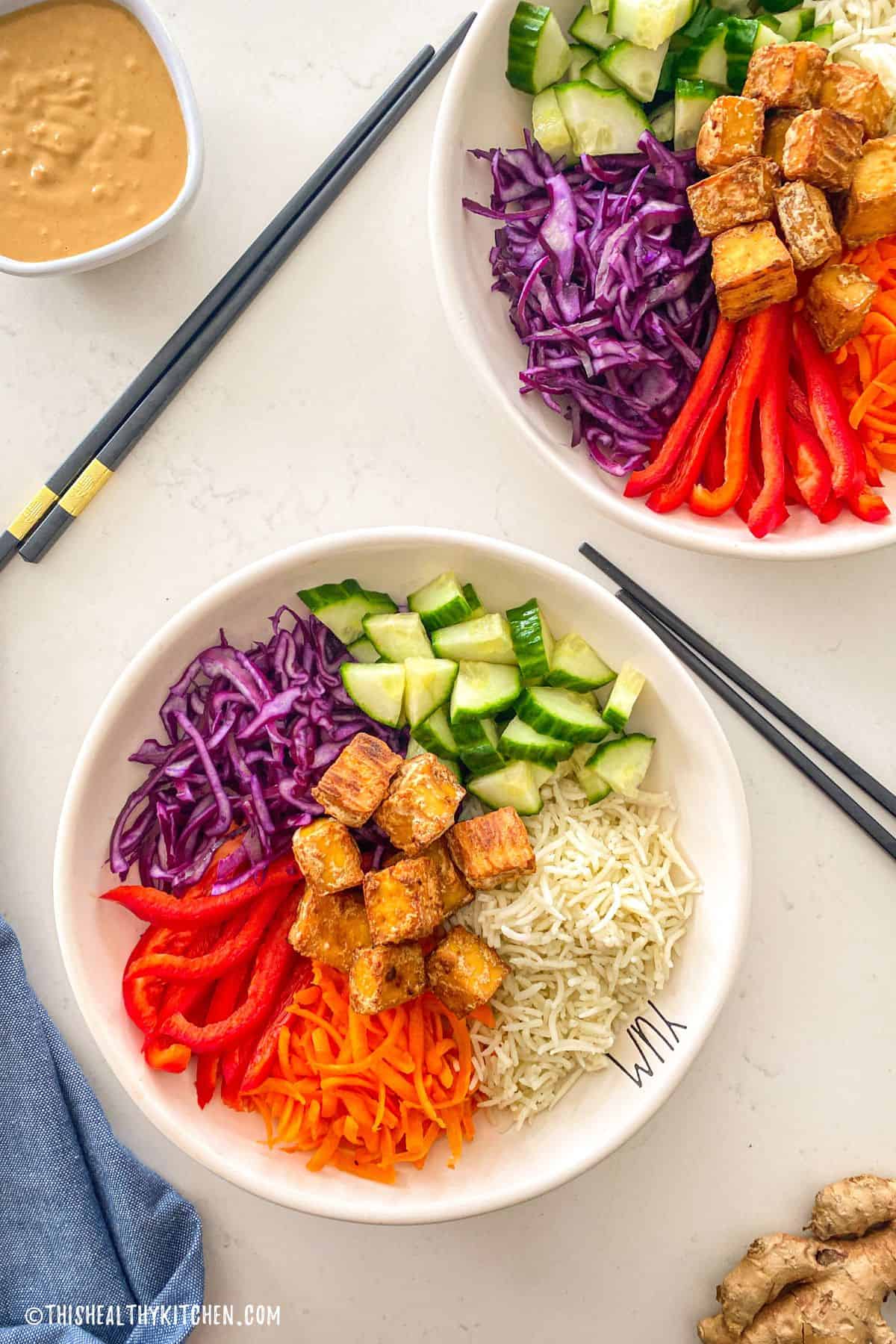 Two bowls of rice, veggies and crispy baked tofu.