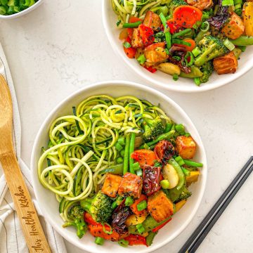 Two bowls with zucchini noodles, Szechuan tofu, and veggies.