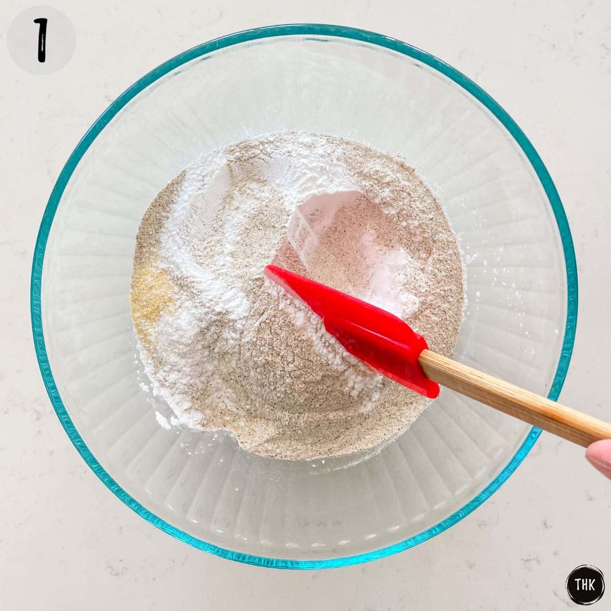 Flour, baking powder and seasoning being mixed in a large bowl.