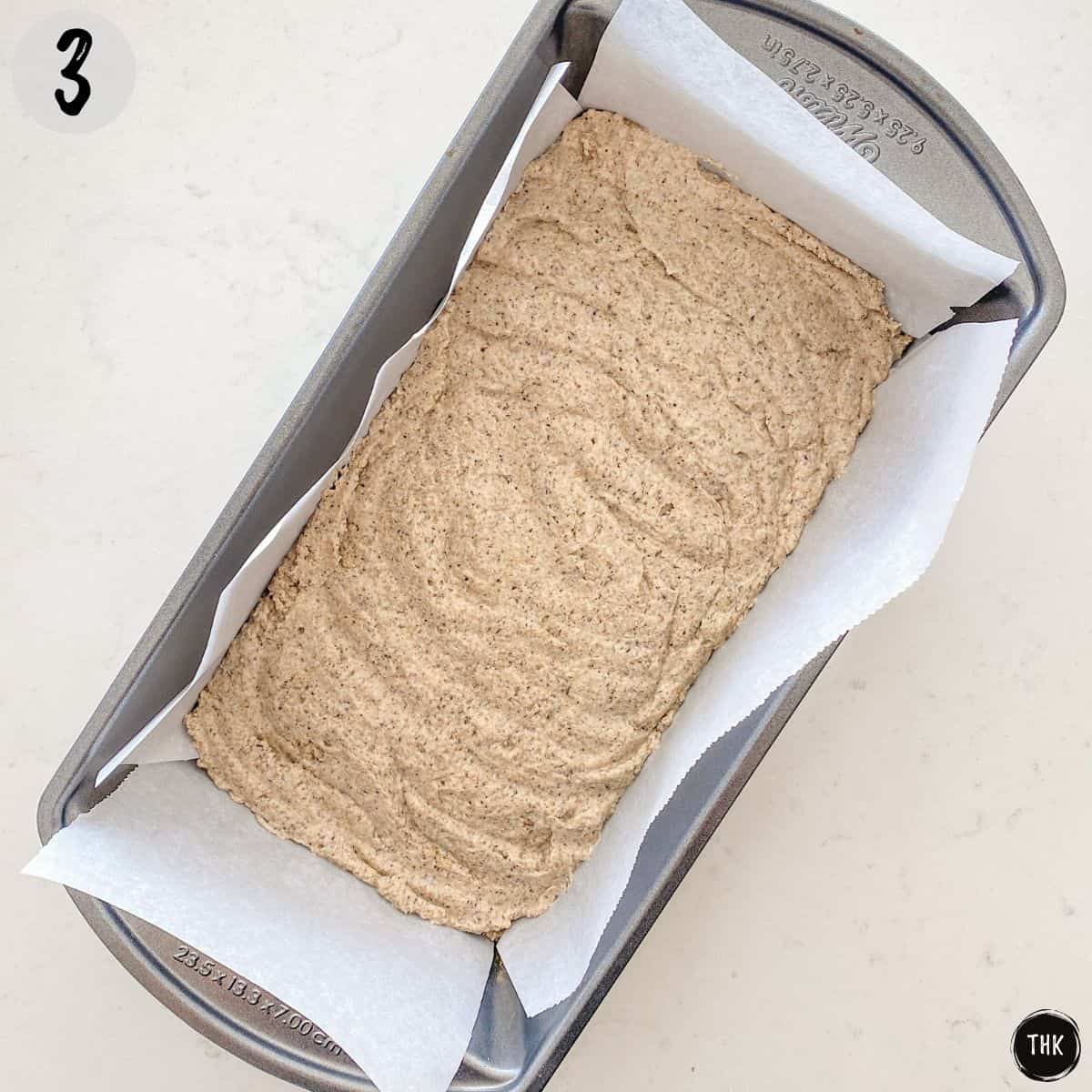 Bread batter inside loaf pan before baking.