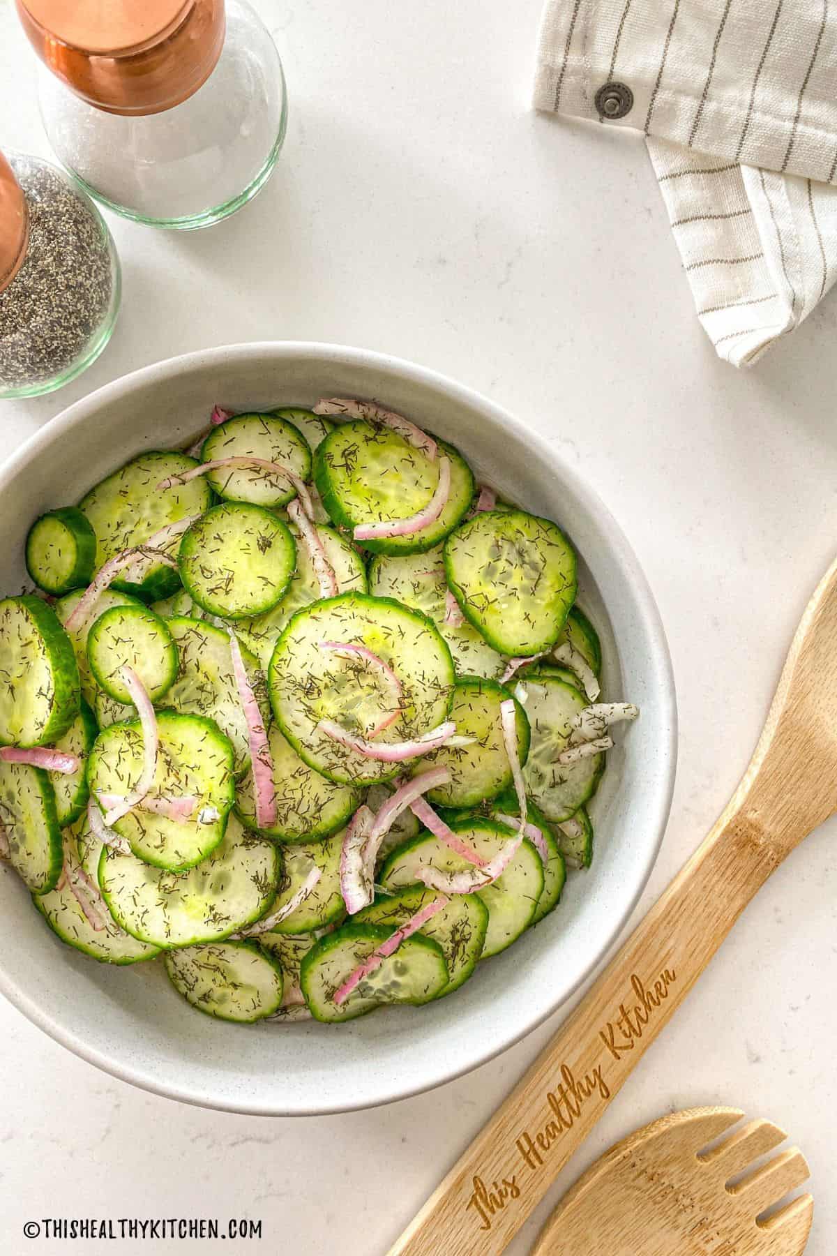 Cucumber salad with dill in serving bowl.