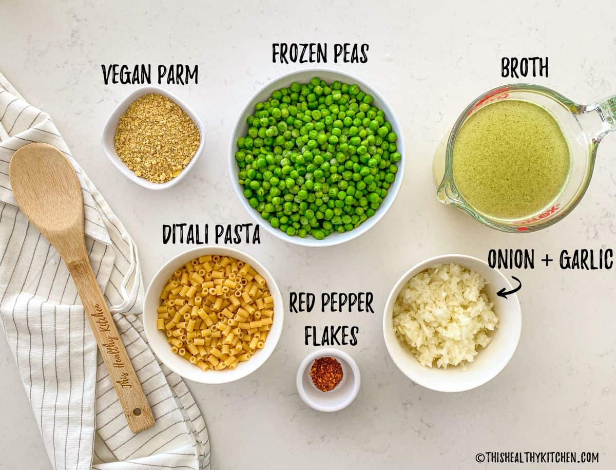 Bowls of ingredients to make vegan pasta e piselli on countertop.
