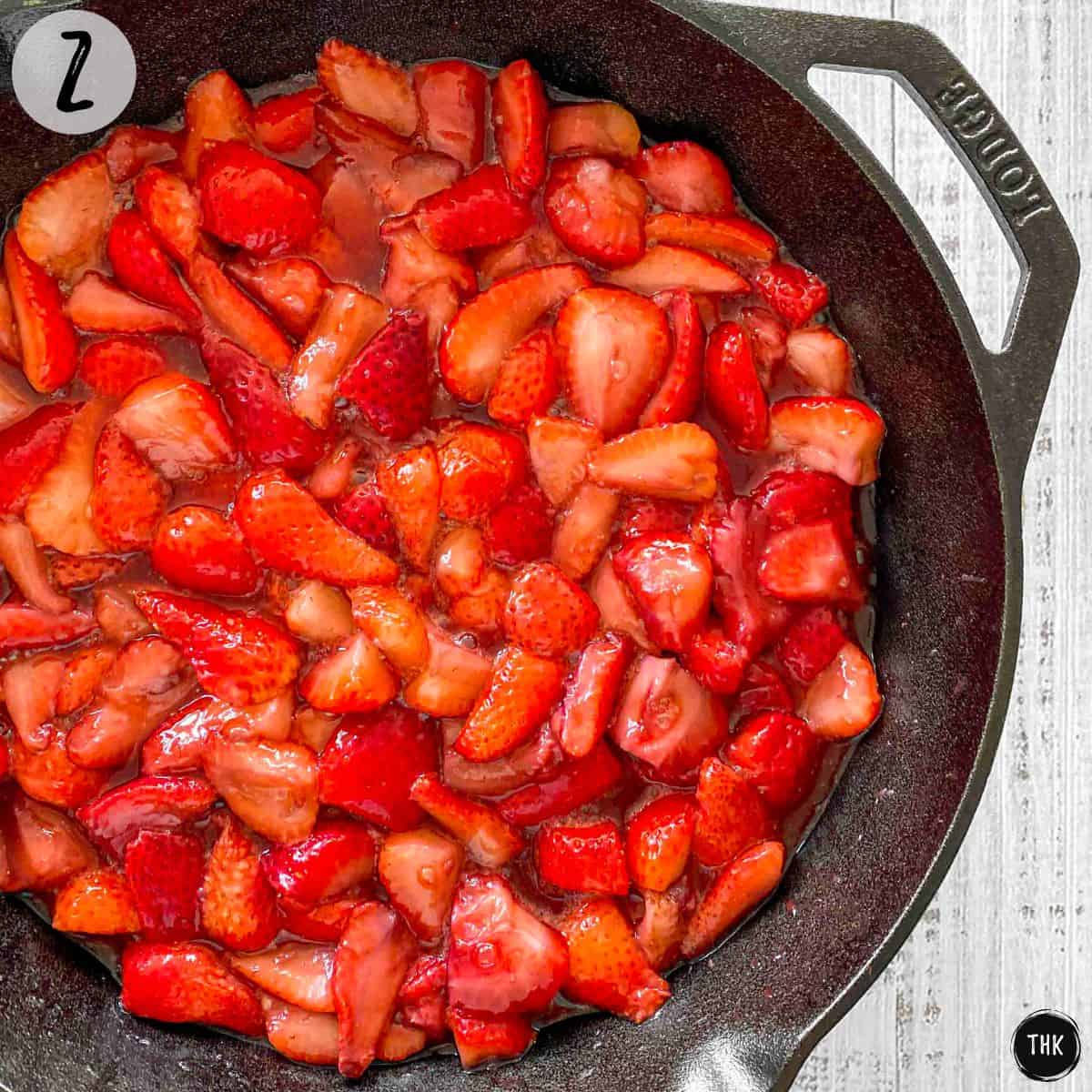 Cooked strawberries inside cast iron pan.