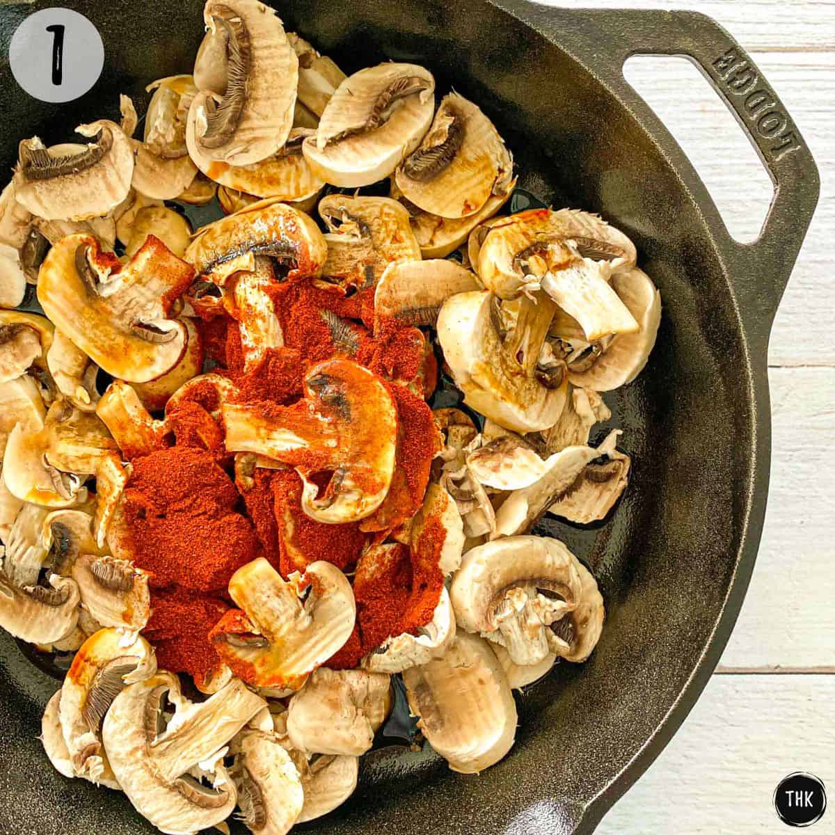 Mushrooms and paprika inside cast iron pan.