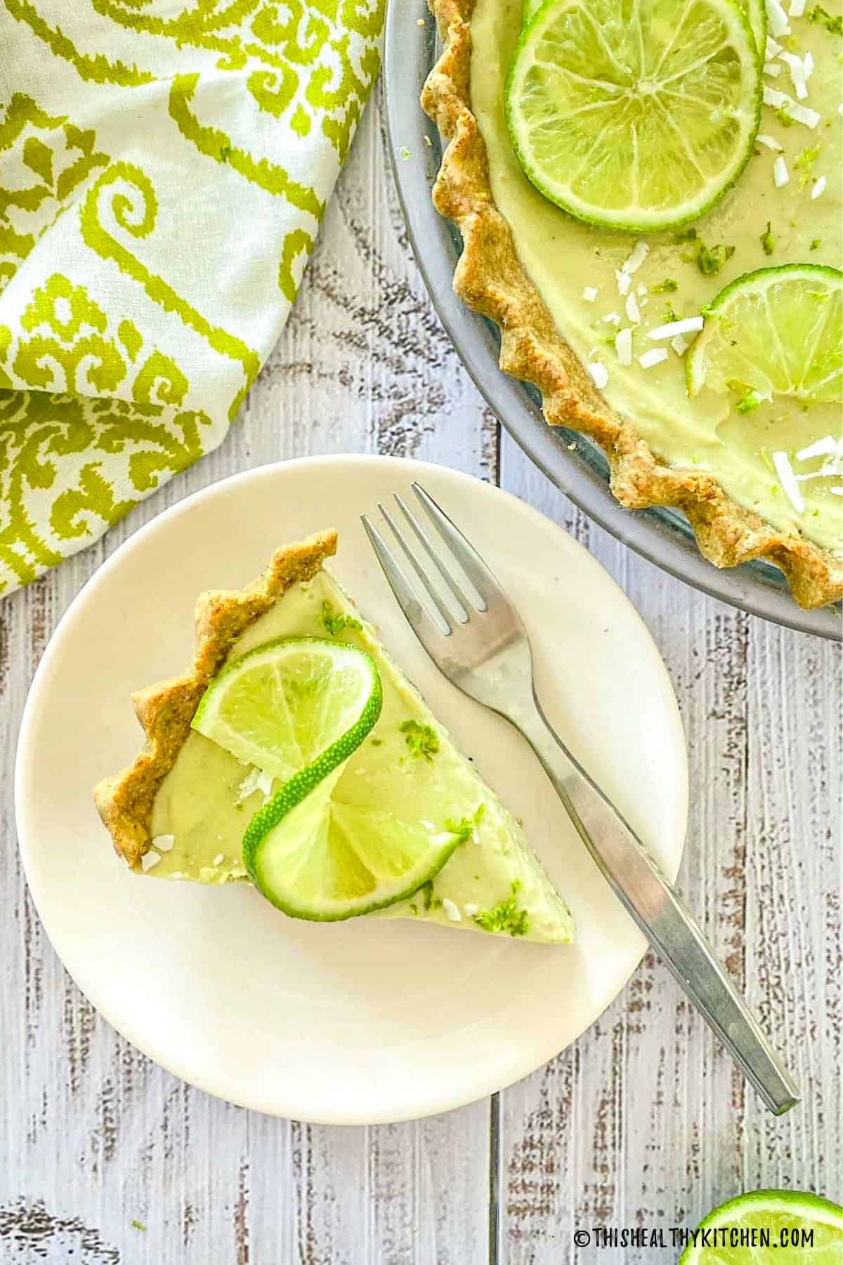 Slice of key lime pie in plate with fork.
