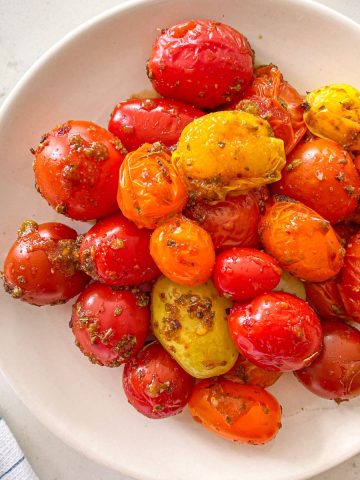 Close up of white plate with marinated air fryer tomatoes.